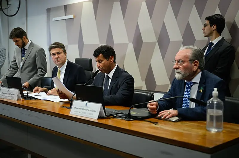 Relator Doutor Luizinho lê o parecer na mesa da comissão mista da MP 1.370, ao lado do presidente do colegiado, senador Camilo Santana